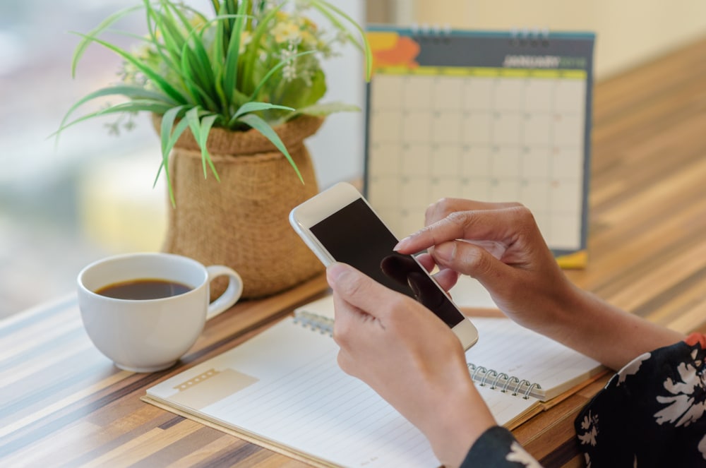 Person using phone with calendar