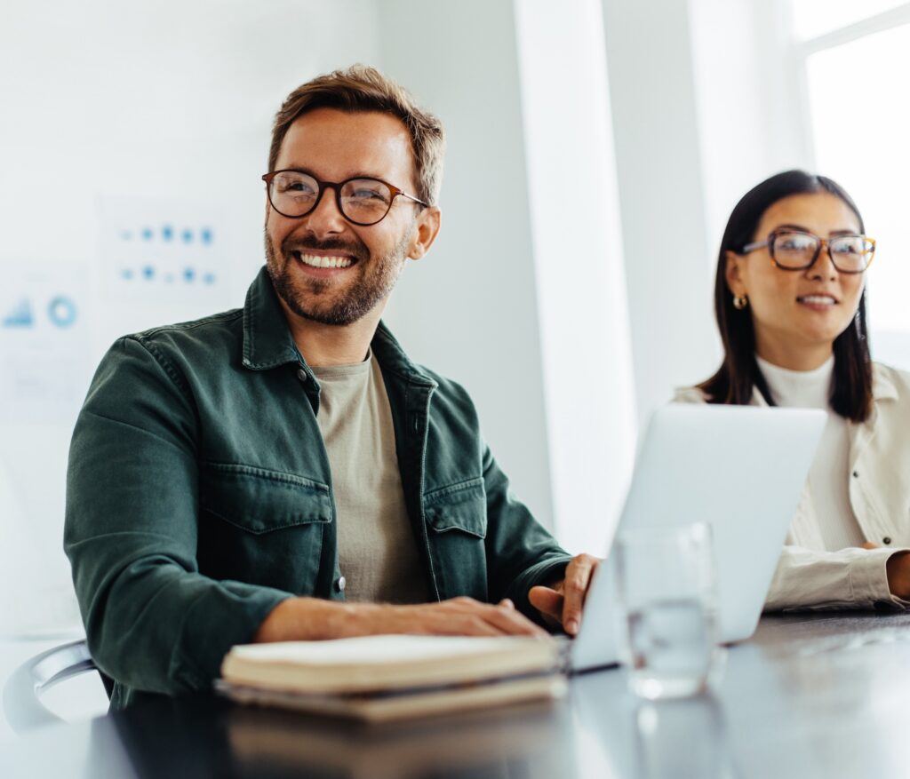 Happy business man listening to a discussion in an office